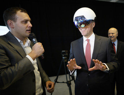 Ben Holfeld of Accenture's AI practice, left, helps Canadian Finance Minister Bill Morneau, right, use a DAQRI Smart Helmet during the launch of the Vector Institute for AI at the MaRs Discovery District in Toronto, Ont. on Thursday, March 30, 2017