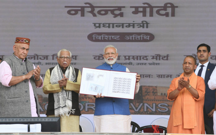 The Prime Minister, Shri Narendra Modi at the unveiling ceremony of the several projects in Varanasi, Uttar Pradesh on February 19, 2019. The Governor of Uttar Pradesh, Shri Ram Naik, the Chief Minister of Uttar Pradesh, Yogi Adityanath and the Minister of State for Communications (I/C) and Railways, Shri Manoj Sinha are also seen.